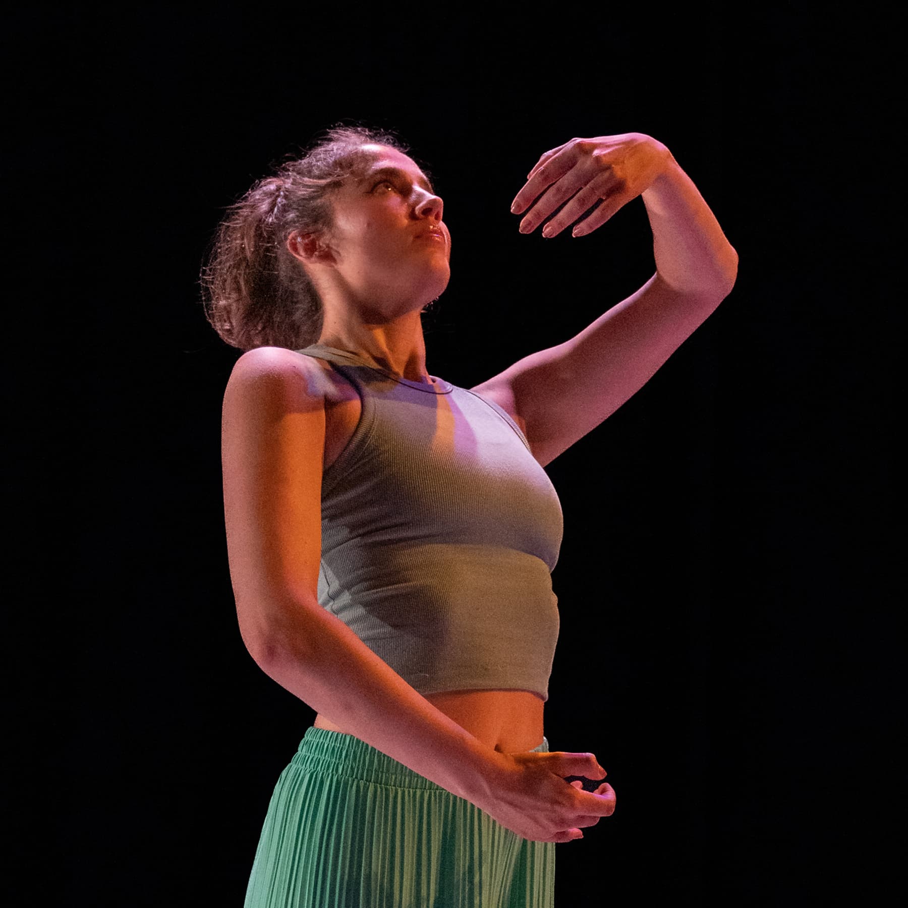 Alex Carrington, wearing red, curls and twists her arms and legs.