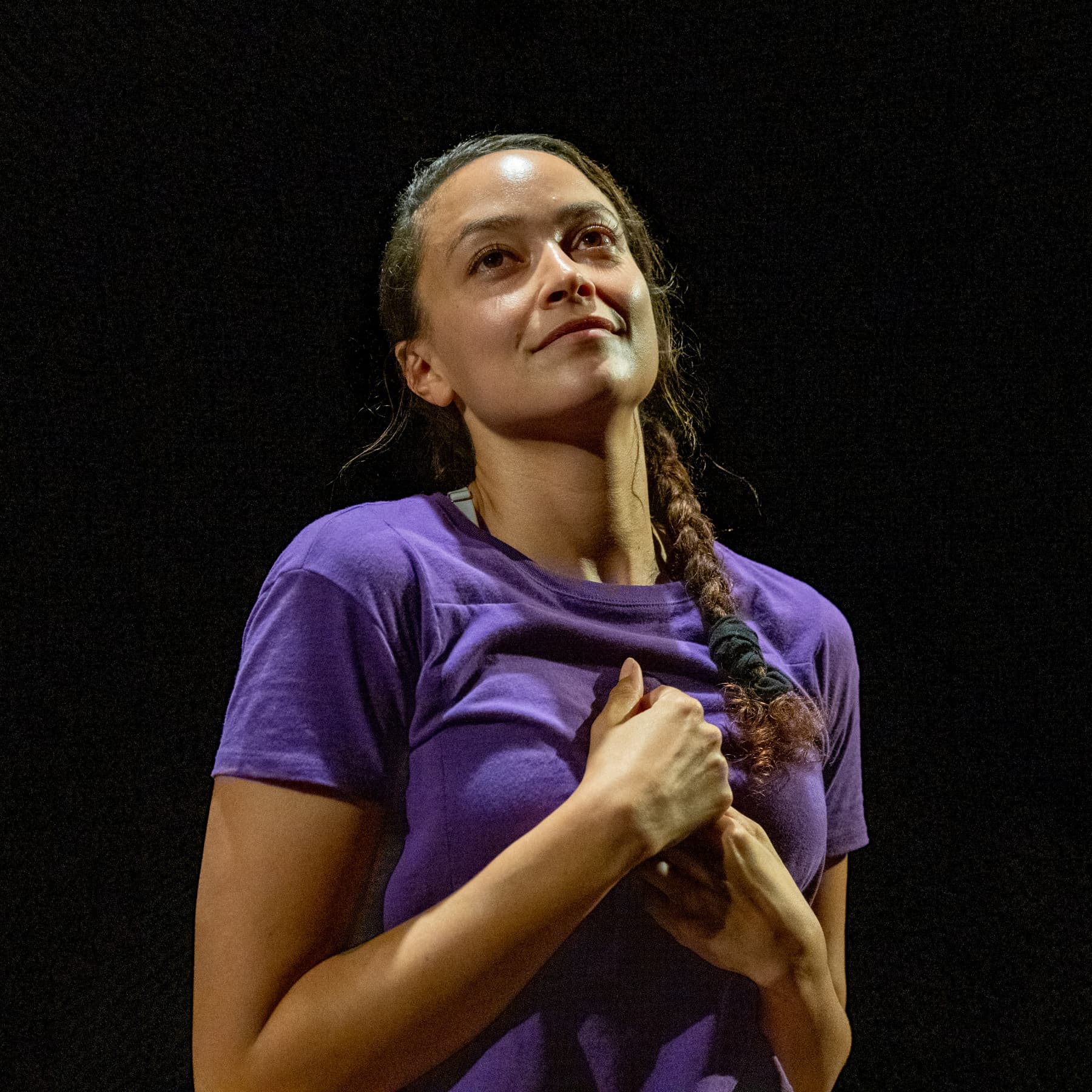 Shareen DeRyan, wearing turquoise and maroon, places her hands in the air with specificity.